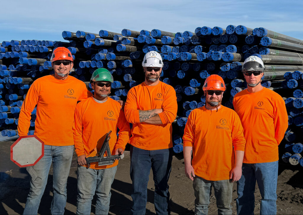 Team Members in HSE gear stand with OCTG pipe